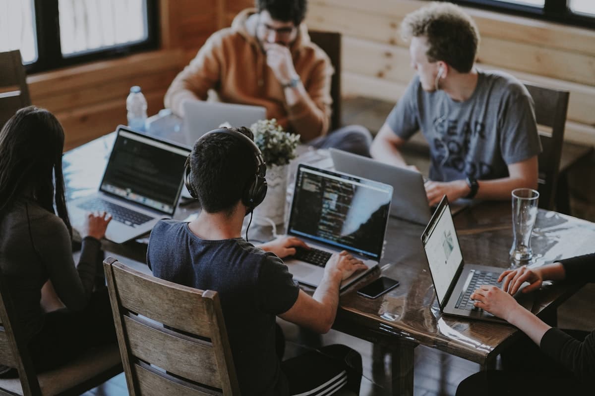 Developers collaborating around laptops at a table